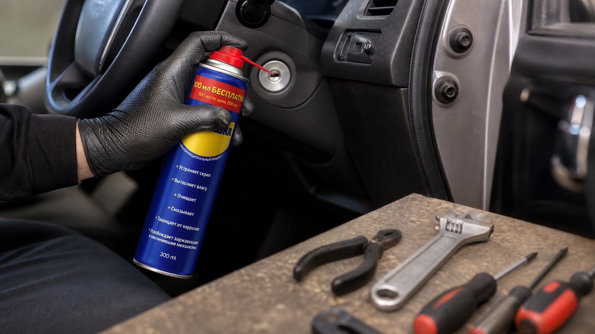 Рука в перчатке наносит универсальную смазку WD40 на замок зажигания.