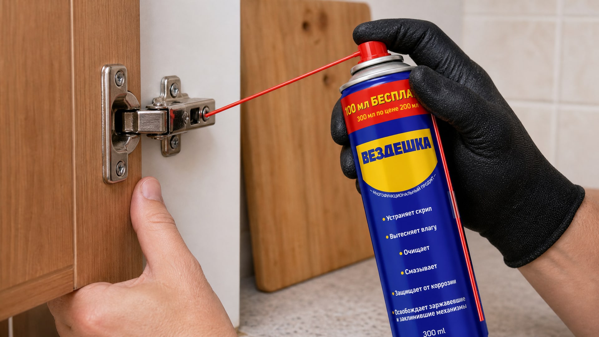 Рука в перчатке наносит универсальную смазку wd-40 на дверцу шкафа.